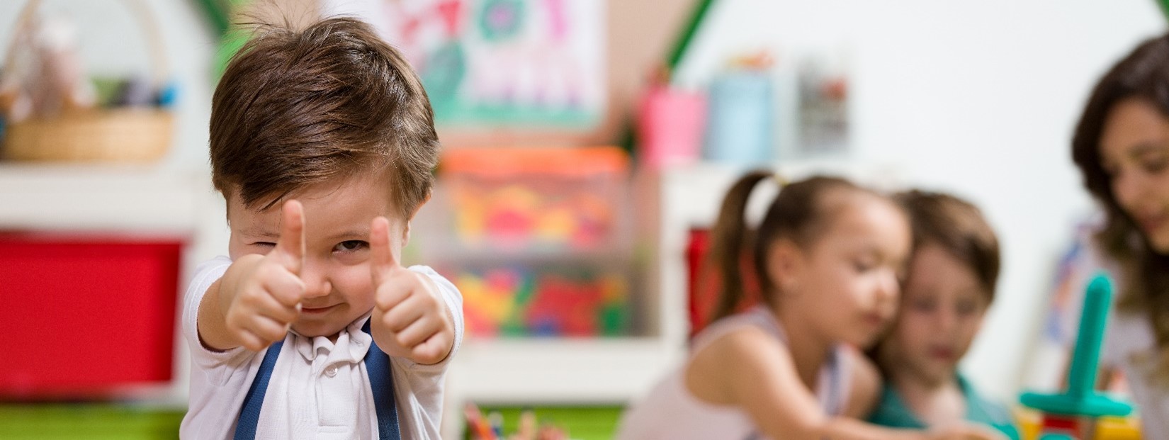 Child giving a thumbs up.