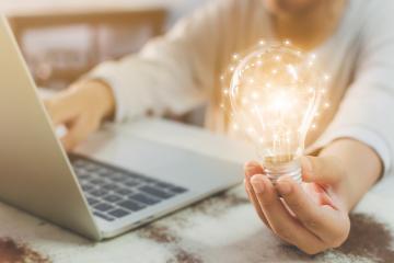 Hand holding shining lightbulb