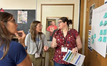 Three teachers discussing a project at the MASL Summer Professional Development 2025 event