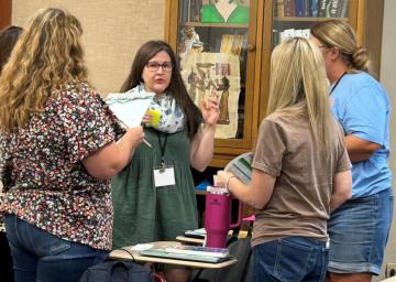 Four librarians working on a project together at the MASL 2025 Summer PD event